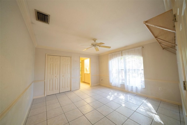 unfurnished bedroom with a closet, visible vents, crown molding, and light tile patterned floors