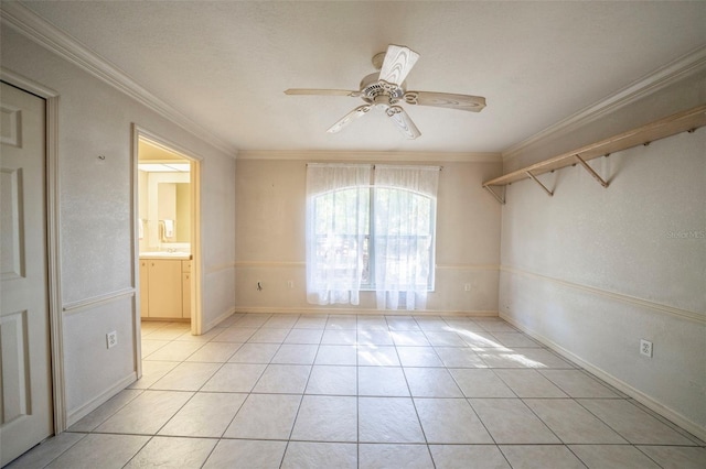 unfurnished room featuring light tile patterned floors, ceiling fan, baseboards, and crown molding