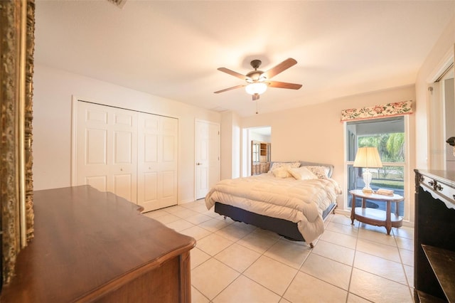 bedroom with a closet, light tile patterned flooring, and a ceiling fan