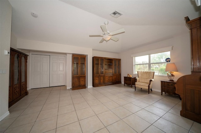 living area featuring light tile patterned floors, baseboards, visible vents, a ceiling fan, and vaulted ceiling