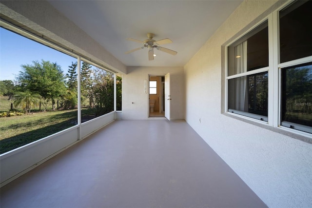 unfurnished sunroom with a ceiling fan