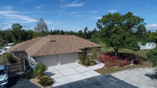 ranch-style house with a garage, concrete driveway, and roof with shingles