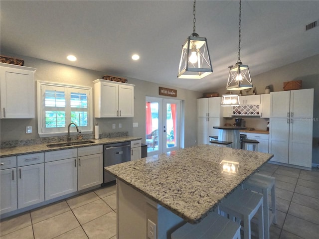 kitchen featuring stainless steel dishwasher, white cabinetry, a sink, and french doors