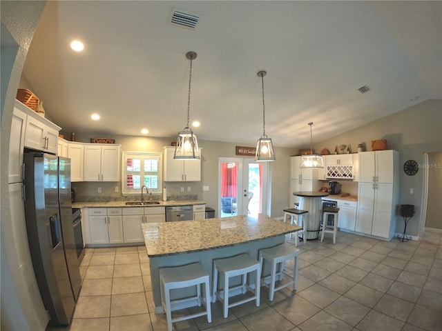 kitchen featuring vaulted ceiling, appliances with stainless steel finishes, a sink, and visible vents