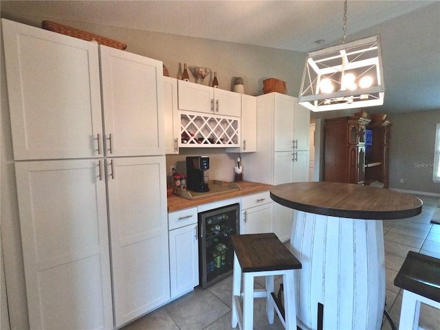 kitchen featuring tile patterned flooring, beverage cooler, and white cabinetry