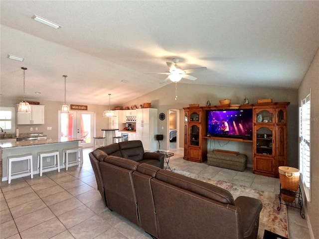 living area featuring light tile patterned flooring, vaulted ceiling, and ceiling fan