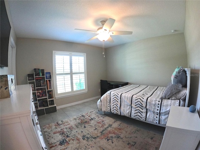 bedroom featuring tile patterned floors, a ceiling fan, and baseboards