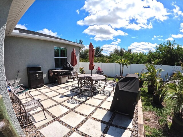 view of patio featuring a fenced backyard, outdoor dining area, and area for grilling