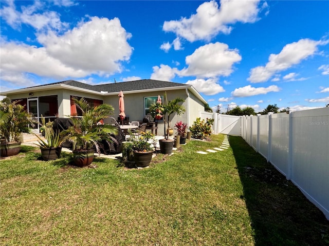 view of yard with a patio area, a fenced backyard, and a gate