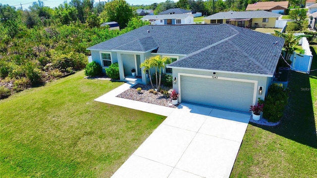 ranch-style home featuring an attached garage, a front lawn, concrete driveway, and roof with shingles