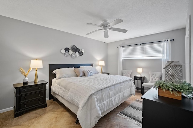 bedroom with a textured ceiling, ceiling fan, and baseboards