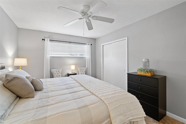 bedroom with ceiling fan, a textured ceiling, baseboards, and a closet