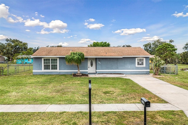 ranch-style home featuring fence, a front lawn, and stucco siding