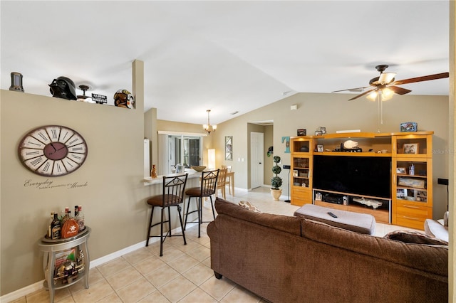 living room with baseboards, ceiling fan with notable chandelier, light tile patterned flooring, and vaulted ceiling