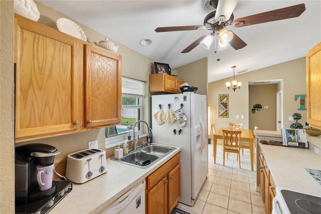 kitchen with light countertops, lofted ceiling, light tile patterned flooring, white appliances, and a sink