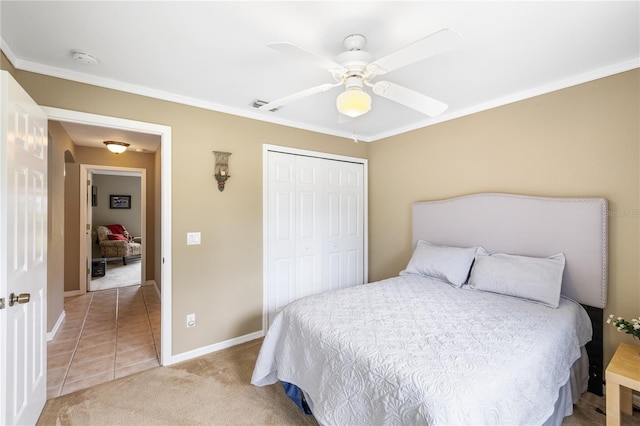 bedroom featuring a closet, light carpet, baseboards, and crown molding