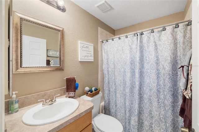 full bath featuring visible vents, curtained shower, toilet, a textured wall, and vanity