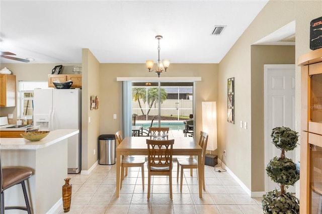 dining room featuring light tile patterned floors, visible vents, baseboards, and ceiling fan with notable chandelier