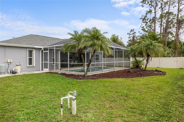 view of yard with glass enclosure, fence, and a fenced in pool