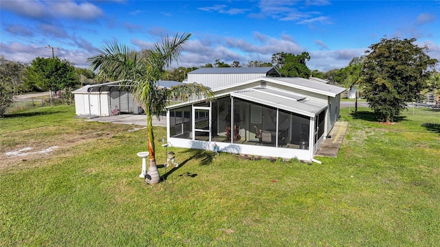 back of property featuring a carport, a sunroom, and a yard