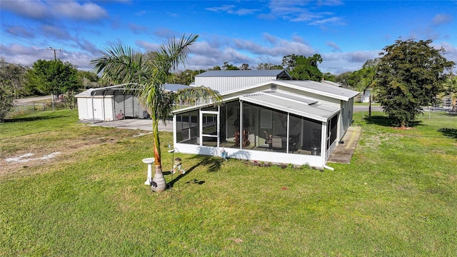 back of property featuring a carport, a sunroom, and a yard