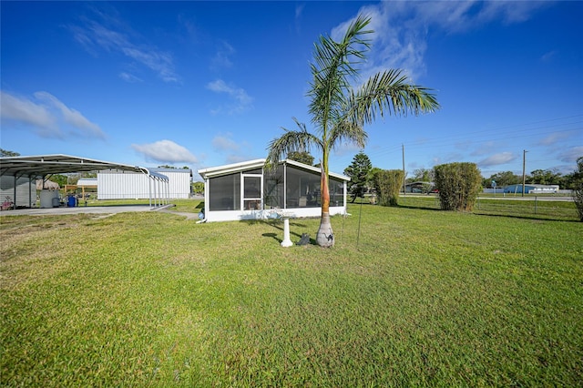 view of yard with a detached carport and a sunroom