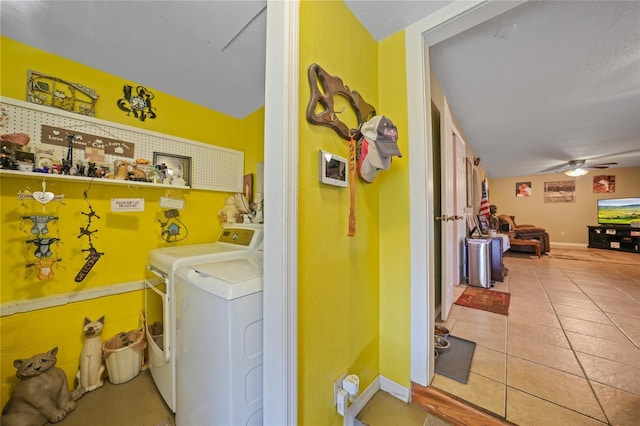 clothes washing area with tile patterned flooring, baseboards, ceiling fan, and washer and dryer