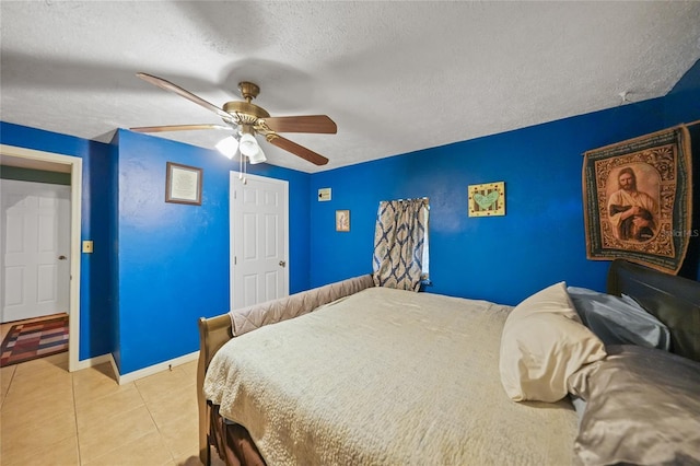 tiled bedroom featuring ceiling fan, baseboards, and a textured ceiling