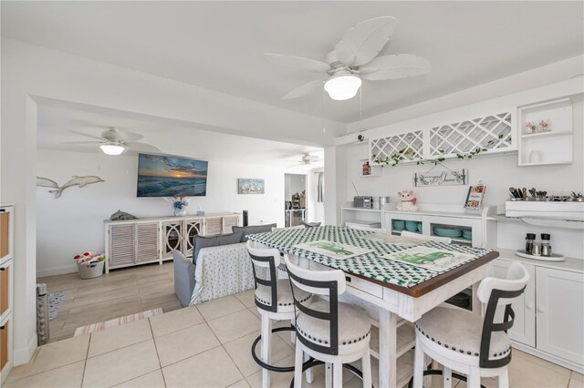 dining space featuring ceiling fan and light tile patterned floors