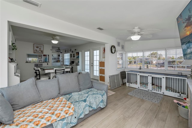 living room featuring plenty of natural light, visible vents, and wood finished floors