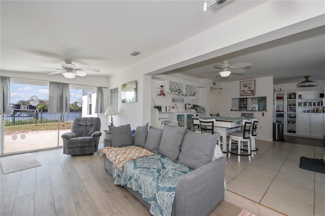 living area with ceiling fan, visible vents, and light wood-style floors