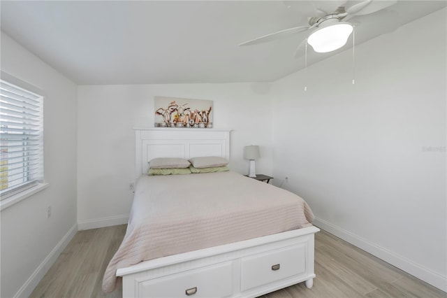 bedroom with light wood-style floors, ceiling fan, and baseboards