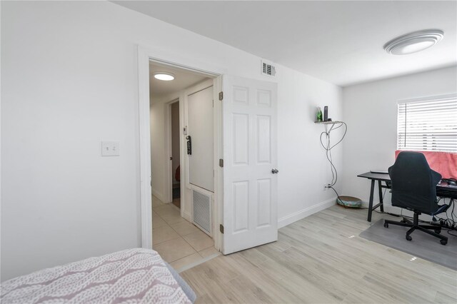 bedroom with light wood-type flooring, visible vents, and baseboards