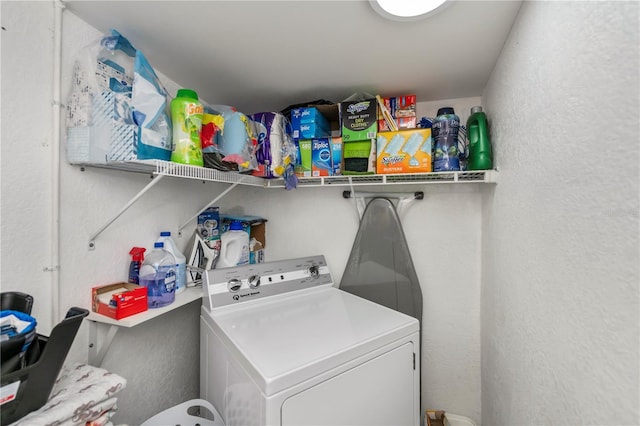 clothes washing area featuring laundry area, washer / clothes dryer, and a textured wall