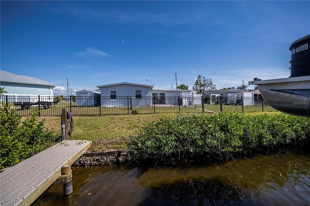 view of dock featuring a lawn and fence