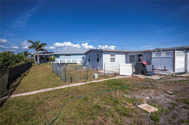 rear view of property with a fenced backyard and a lawn