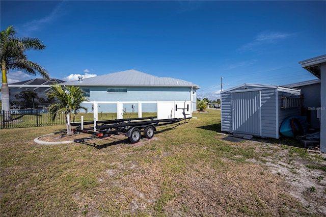 view of yard featuring a storage unit, fence, and an outdoor structure