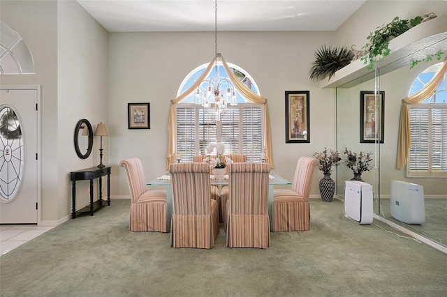 dining room featuring a notable chandelier, light tile patterned floors, baseboards, and light colored carpet