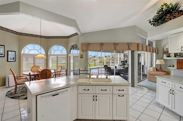 kitchen featuring white dishwasher, white cabinetry, light countertops, and a center island