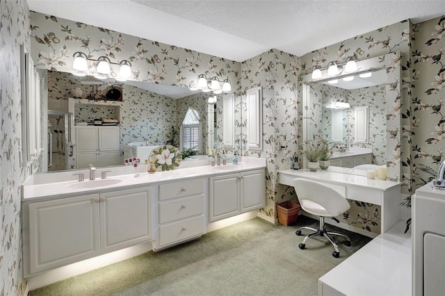 full bath with a textured ceiling, a sink, a shower stall, double vanity, and wallpapered walls