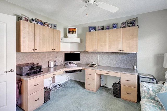 office featuring a ceiling fan, light colored carpet, built in study area, and a textured ceiling