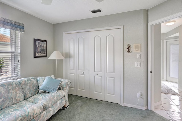 living room with visible vents, a textured wall, and light carpet