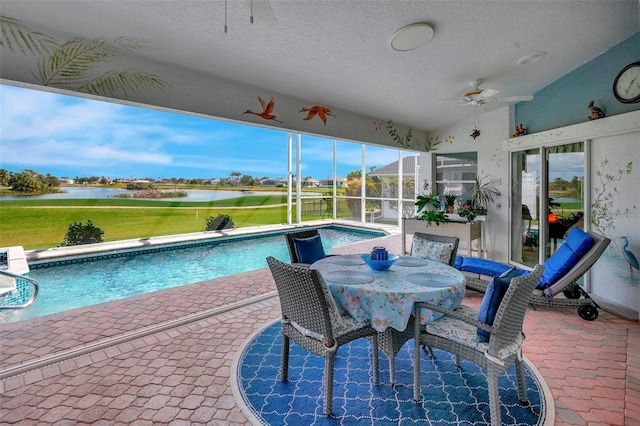 pool featuring a patio area, a lanai, a water view, and ceiling fan