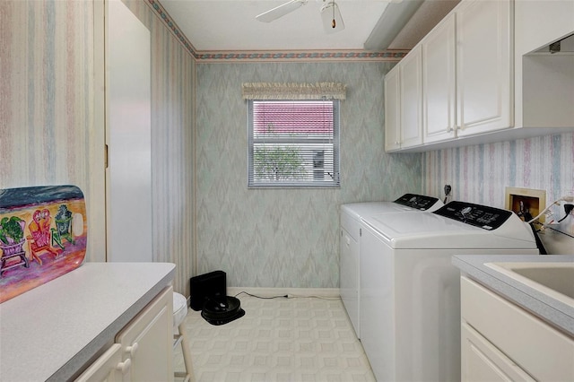 clothes washing area with ceiling fan, washer and clothes dryer, cabinet space, and wallpapered walls