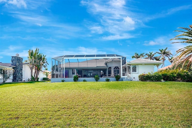 rear view of property featuring glass enclosure and a yard