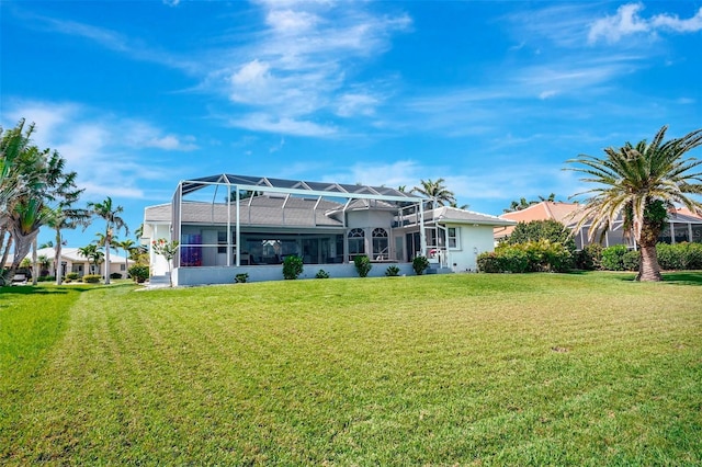 back of house with a lanai and a lawn