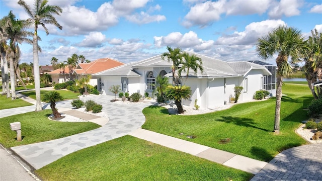 view of front of home featuring a garage, concrete driveway, a tiled roof, stucco siding, and a front lawn