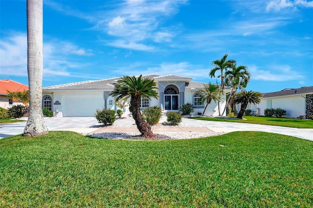 view of front of home with a front yard, concrete driveway, and stucco siding