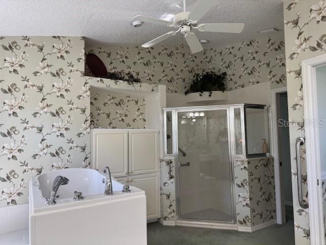 507 Monaco Dr, Punta Gorda, FL 33950 - bathroom featuring wallpapered walls, a shower stall, a garden tub, a ceiling fan, and a textured ceiling