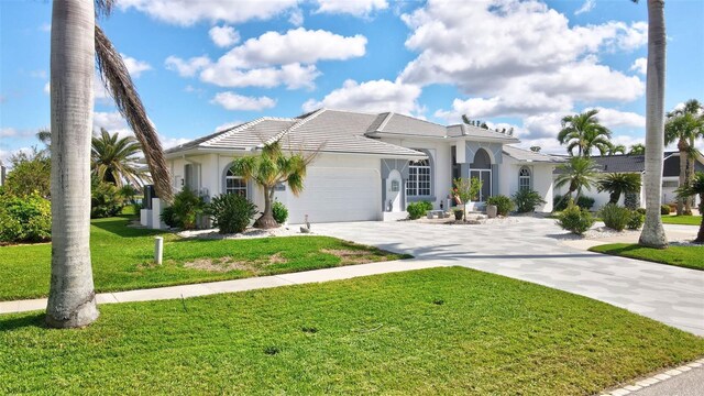 507 Monaco Dr, Punta Gorda, FL 33950 - view of front of home with driveway, an attached garage, stucco siding, a tile roof, and a front yard